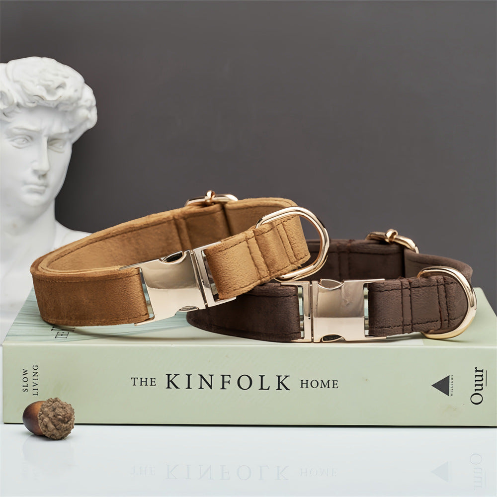 Two dog collars on a book with 'The Kinfolk Home' title, a classical statue head in the background.