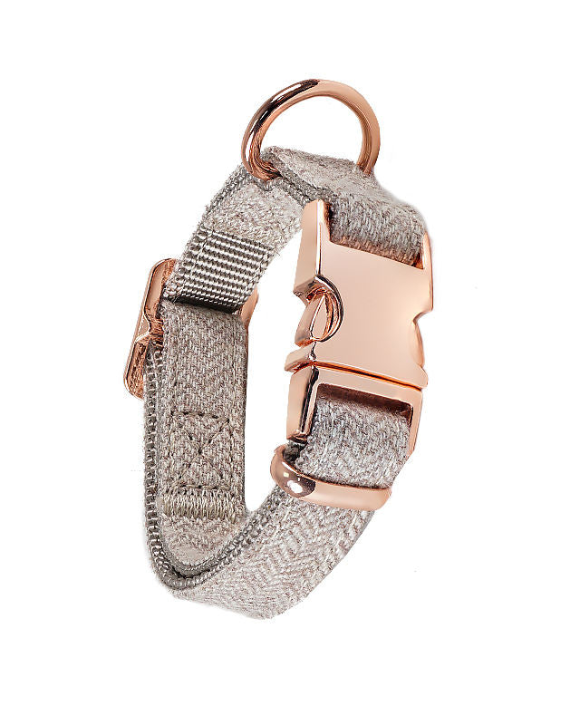 Grey herringbone dog leash with rose gold clasp, coiled on a white background.