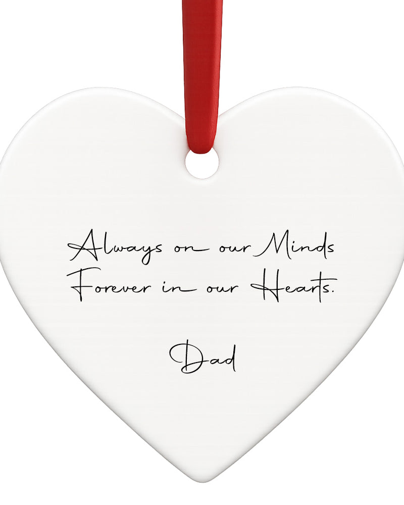 Heart-shaped white ornament with black text and a red ribbon on a white background