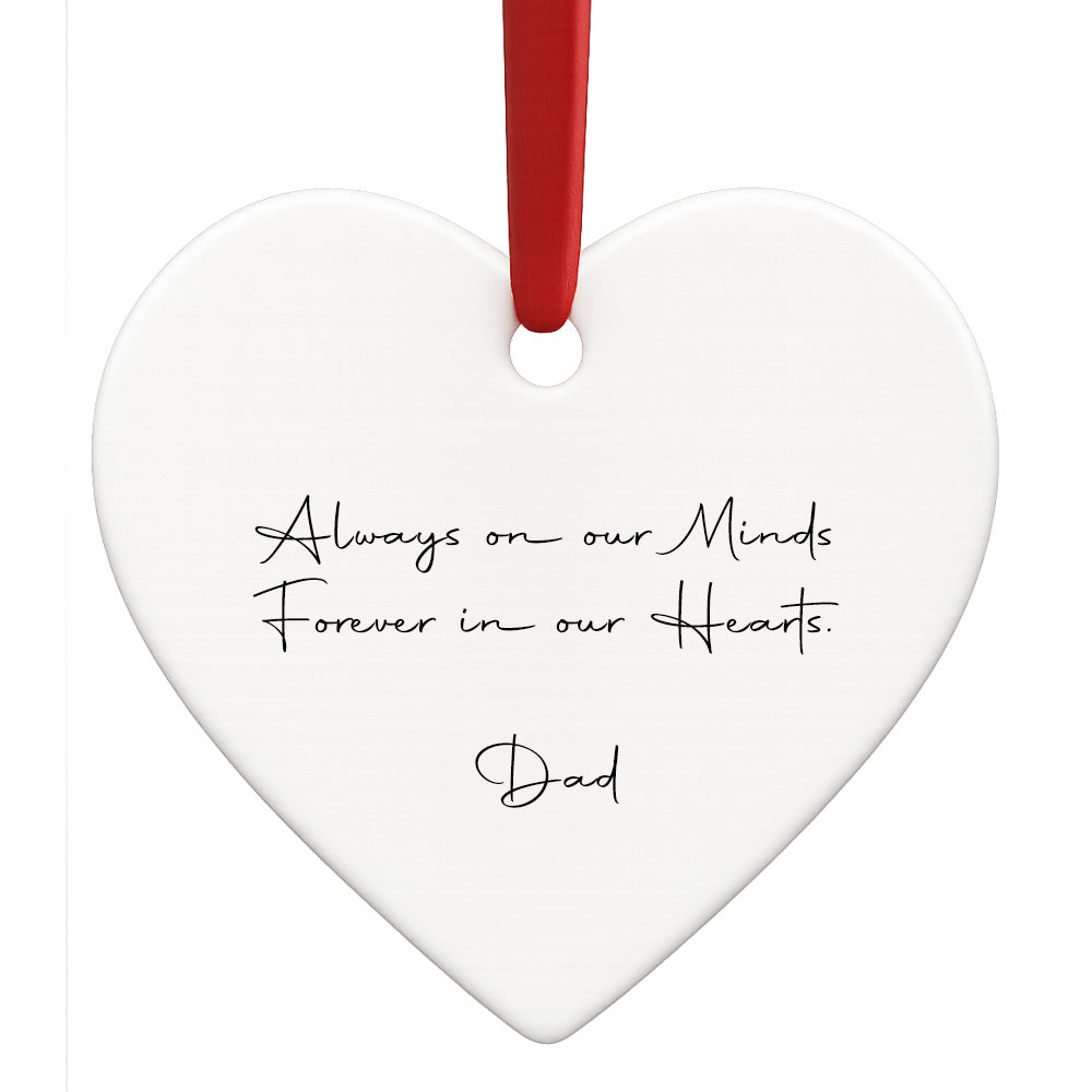 Heart-shaped white ornament with black text and a red ribbon on a white background