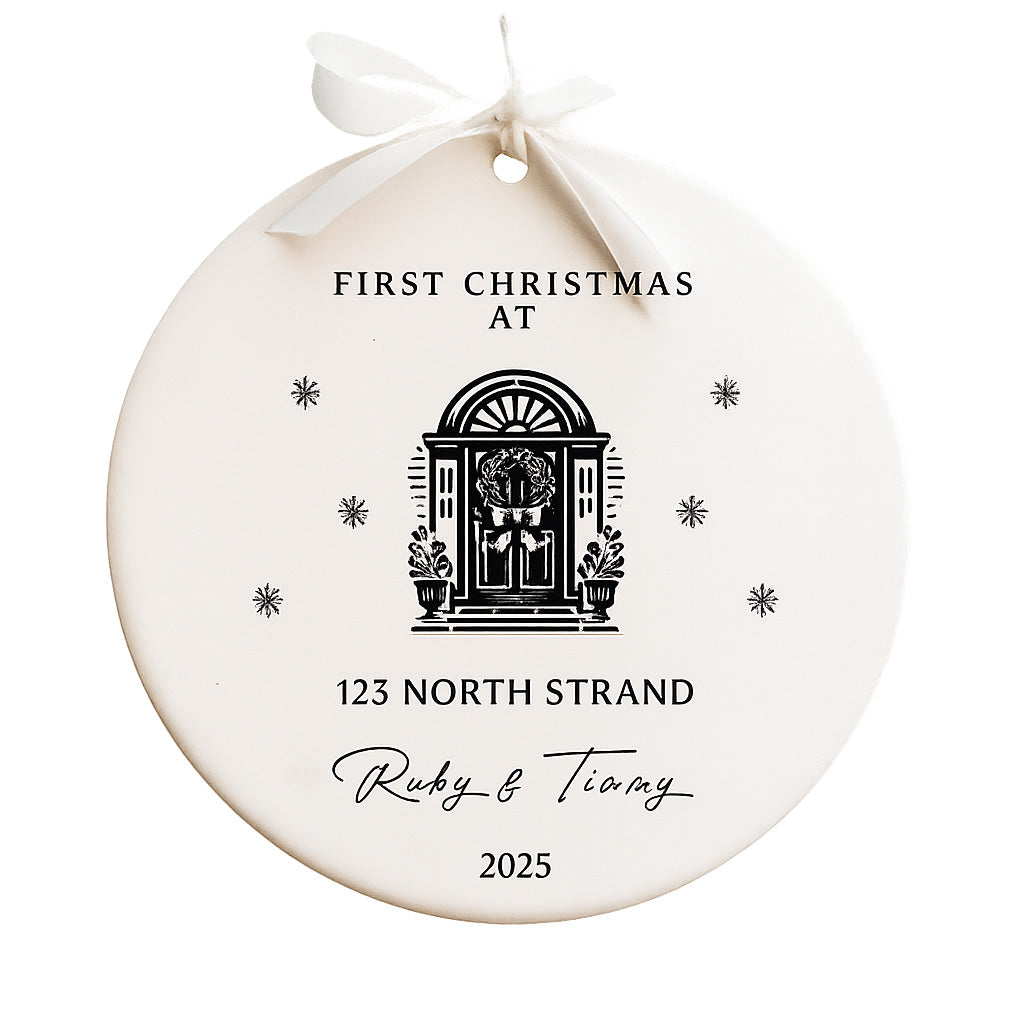 Round white ornament with black text and a door illustration, tied with a white ribbon on a white background.