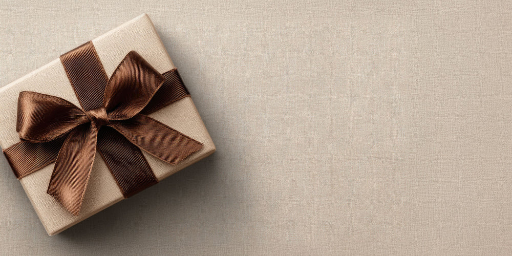 Gift box with a brown ribbon on a beige background