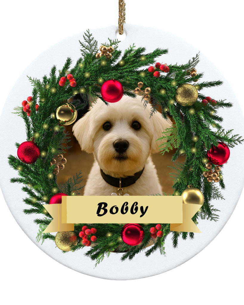 Decorative Christmas ornament with a dog's face surrounded by a festive wreath and the name 'Bobby'.