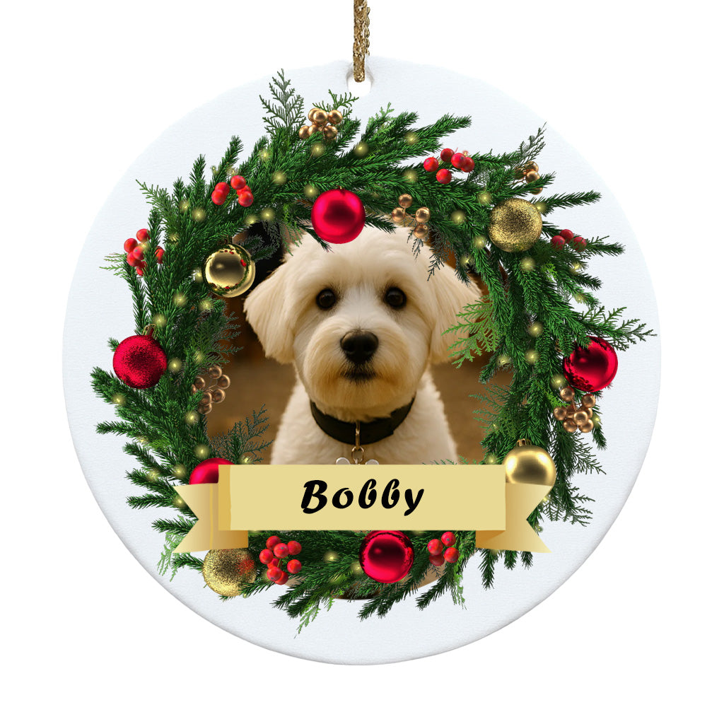 Decorative Christmas ornament with a dog's face surrounded by a festive wreath and the name 'Bobby'.
