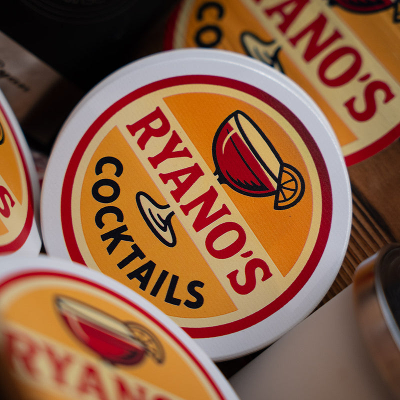 Close-up of 'Ryanos Cocktails' coasters with a blurred background