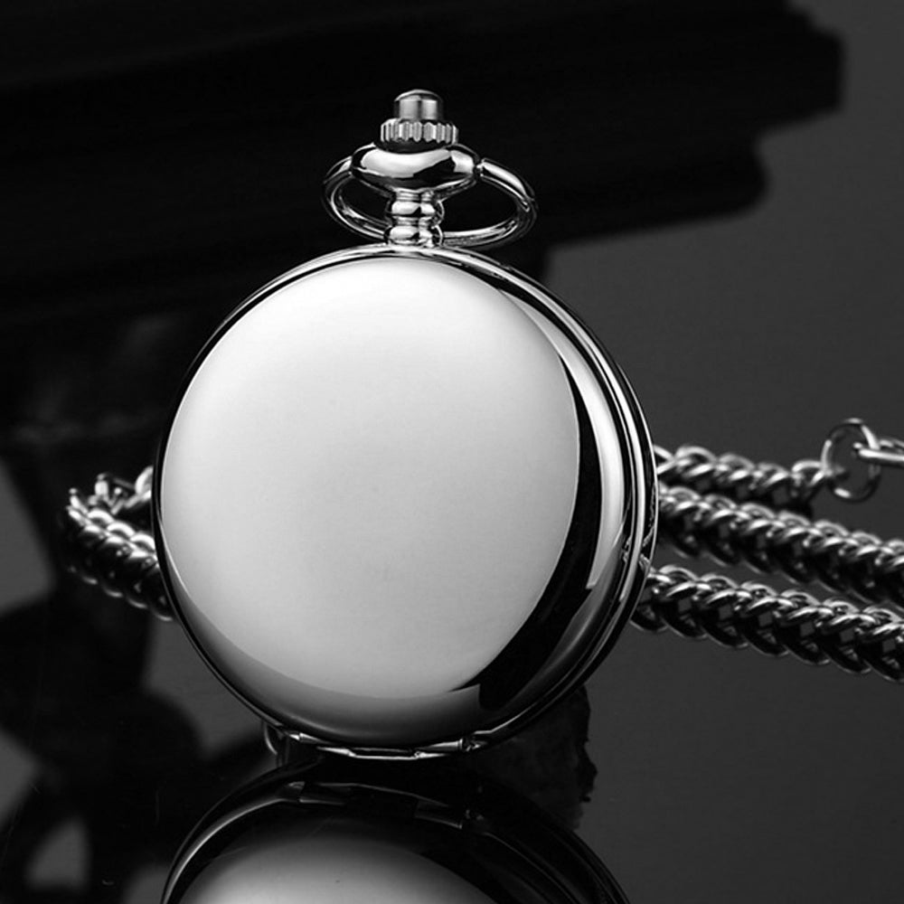 Silver pocket watch with chain on a reflective surface