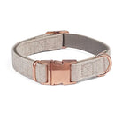 Grey herringbone dog leash with rose gold clasp, coiled on a white background.

