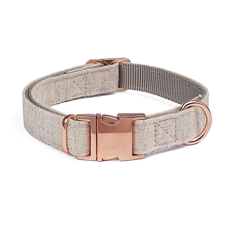 Grey herringbone dog leash with rose gold clasp, coiled on a white background.

